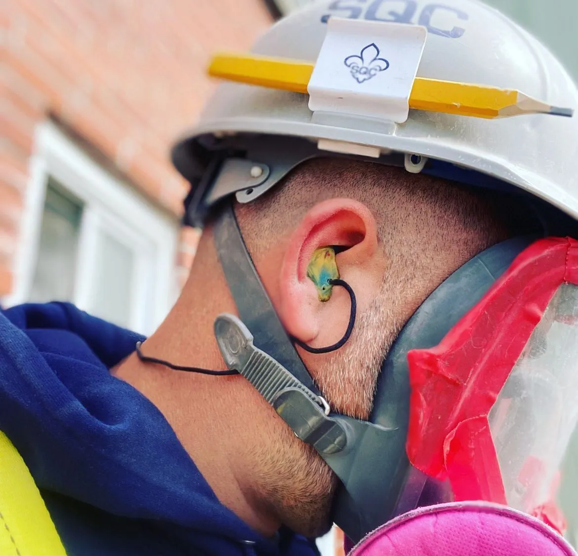 Bouchon d’oreille sur mesure porté par un travailleur en environnement bruyant